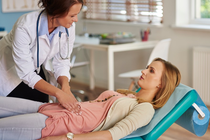 Doctor examining a pregnant woman during a prenatal consultation