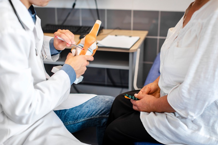Doctor explaining joint anatomy to a patient during a medical consultation