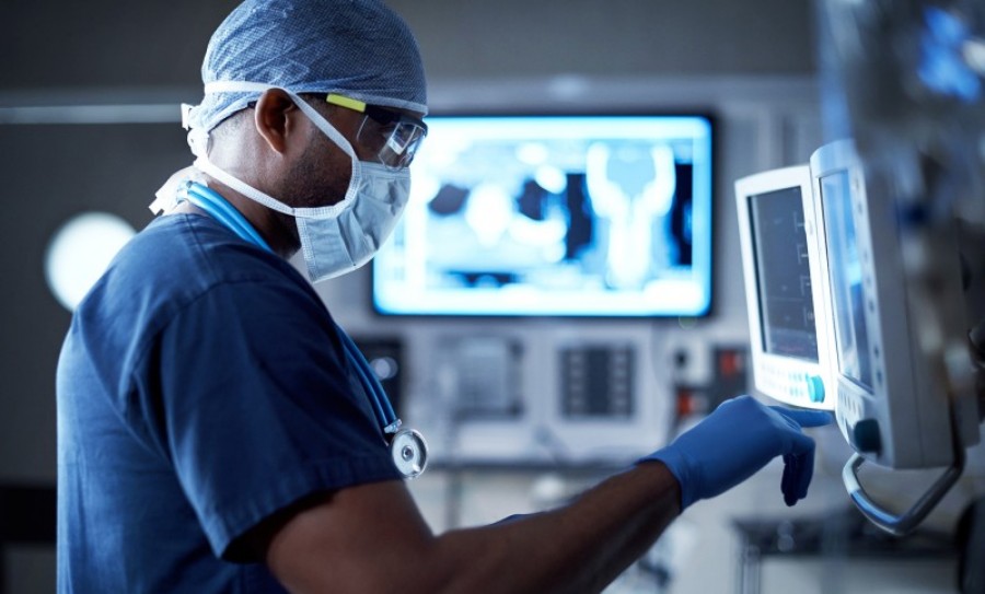 Urologist examining medical equipment during a minimally invasive procedure