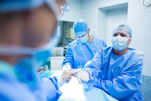 General Surgeon performing a surgical procedure in a modern operating room with a medical team